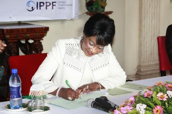 First Lady signing a certificate confirming her committment to family planning initiatives