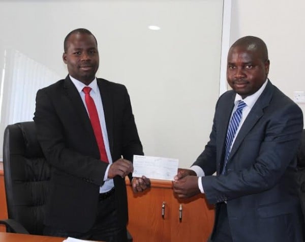 Frank Phiri (left) presenting the cheque