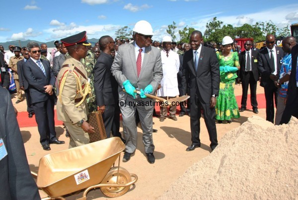 Swagged-out: Mutharika with gold plated shovel as his Louis Vitto brief case is with  ADC