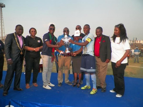 Gyan, Standard Bank MD, Sports Minister present the cup to Lucky Malata.-Photo by Alex Mwezalumo, Nyasa Times