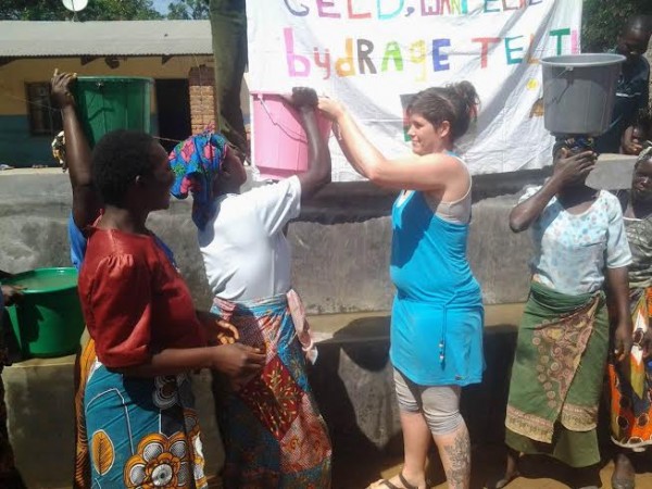 Helps Malawi woman carry the bucket of water