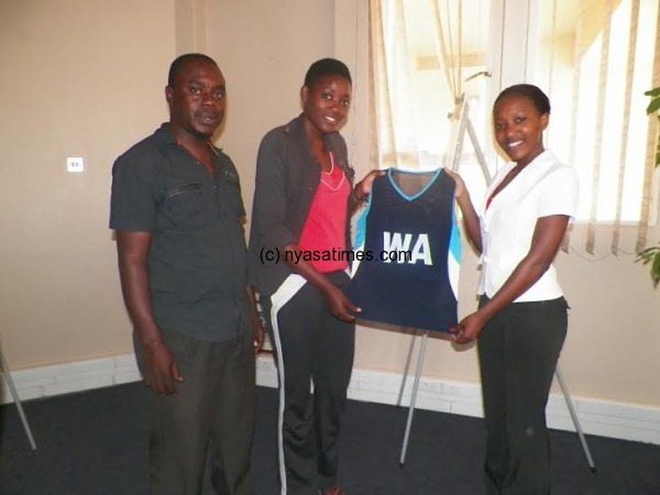 Here you are- Bauleni presents the kit tot eam captain Esther Katungwe as Namaona looks on