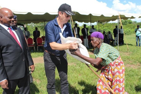 Here you are! Vanneste presenting a bag to a beneficiary while Chiyembekeza looks on