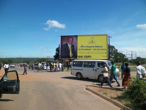Atupele's next stop is Lilongwe and in this photo on Wednesday passers-by in the capital admire a new billboard campaign  erected there