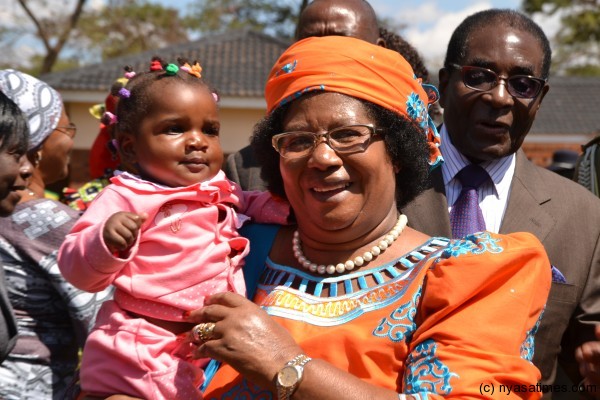 President Banda with a kid in Zimbabwe as Mugabe looks on
