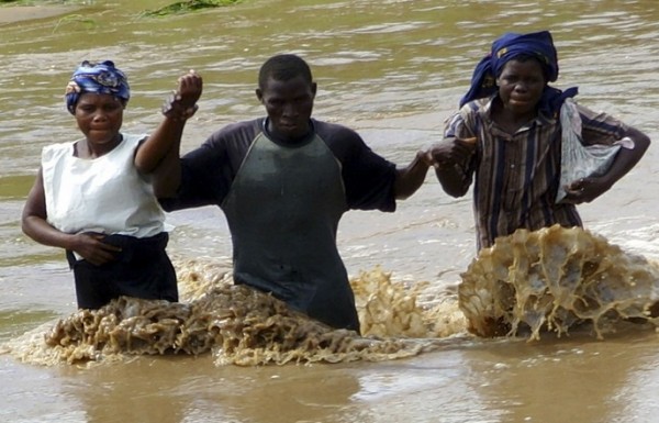 Women rescuing man in flood water