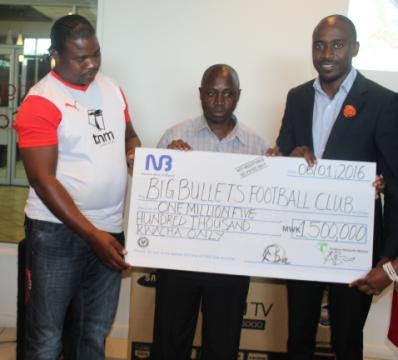 Jonazi (in black jacket) presenting dammy cheque to Bullets FC