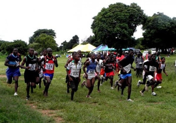 Junior men's athletes , most of them running barefooted and in their ordinary attire