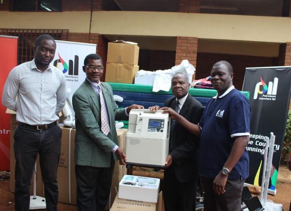 Kadango (R) handing over oxygen concetrator  to hospital advisory committee chair Franck Chipesa and Movete while Dr Kabwere looks on