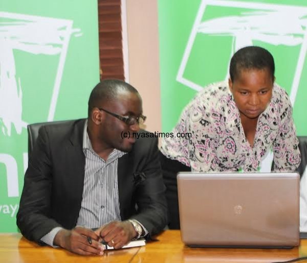We’re excited—Kalomba (right) looks on as a journalist conducts the final draw