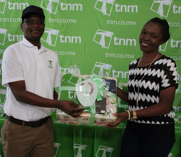 TNM Chief Commercial Officer Daniel Makata (left) presenting the prizes and trophy to Kamphulusa