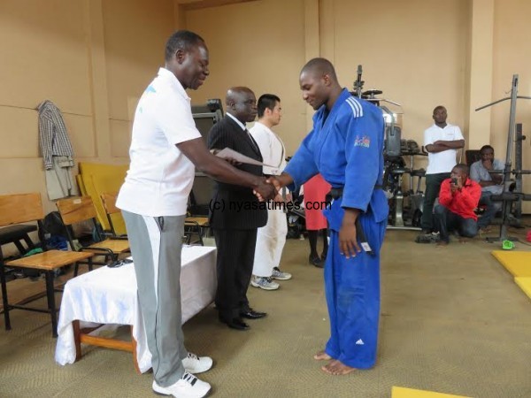 Kanjala presents a certificate to one of the coaches