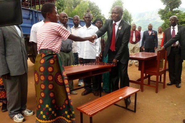 Kanyumba (R) makes a symbolic handover of the desks in Zomba.