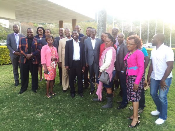 Kasaila (centre, grey suit) pose for a group photo with Malawians resident in Swaziland