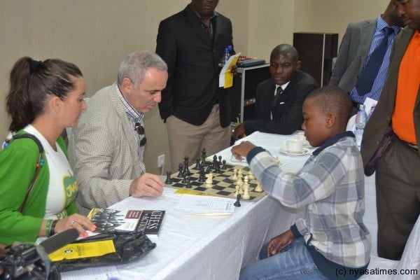 Kasparov playing chess with a junior player