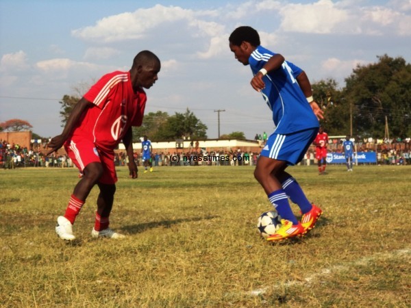 Kondwani Lufeyo with the ball trying to beat a Red Lions defender. -Photo by Elijah Phimbi, Nyasa Times