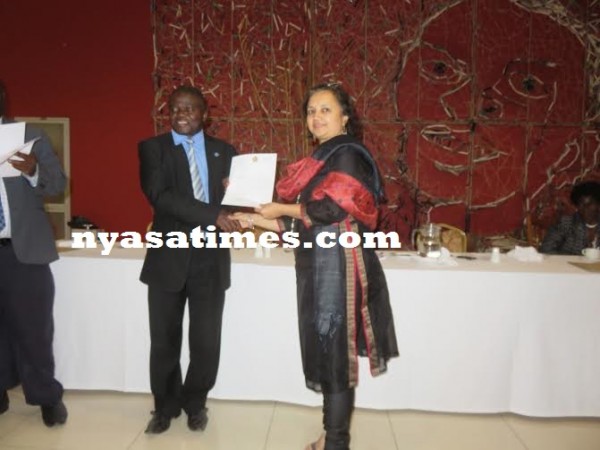 Kumpalume presents a certificate to one of the doctors