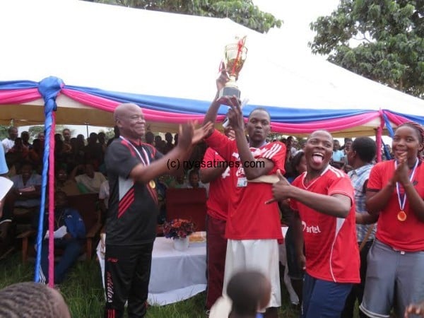 LLTC principal Peter Njunga presents the cup to the champions.