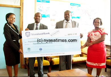 MRA Kapoloma donates the cheque to Commissioner Atanazio Chibwana