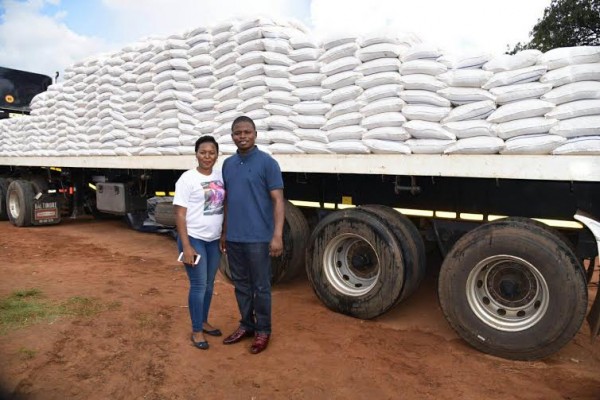 Major 1 and his wife standing before a truck crrying the maize