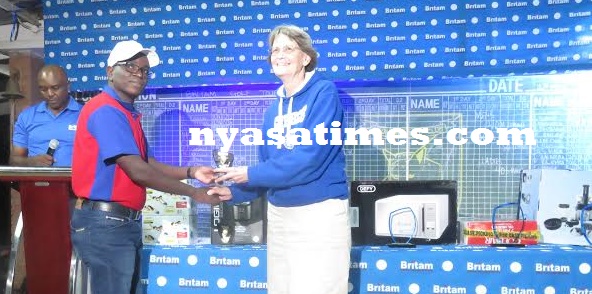 Makeen receives her prize from Britam's Operations Manager Wales Meja