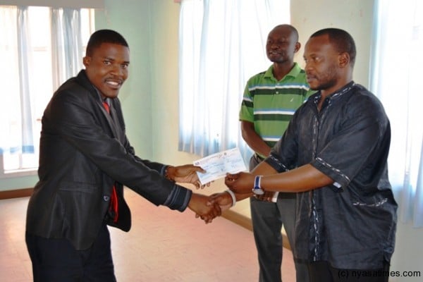 Malawi News Agency Arkangel Tembo turn to receive his cheque
