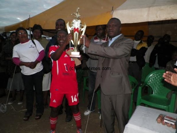 Malinga presents the cup to Bt Zero captain Sungeni Msiska.