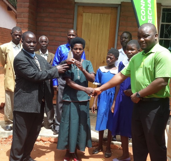 Malisa ( in green t-shirt)  and Paulo in the middle handing over a key to Primary Education Advisor for Nsundwe a Mr Phiri