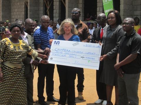 Manguluti in (in grey suit) handing over dummy cheque to the beneficiaries