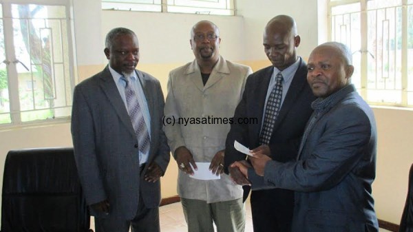 Michael Usi presenting the cheques to Wanderers and Bullets chairmen....Photo Jeromy Kadewere