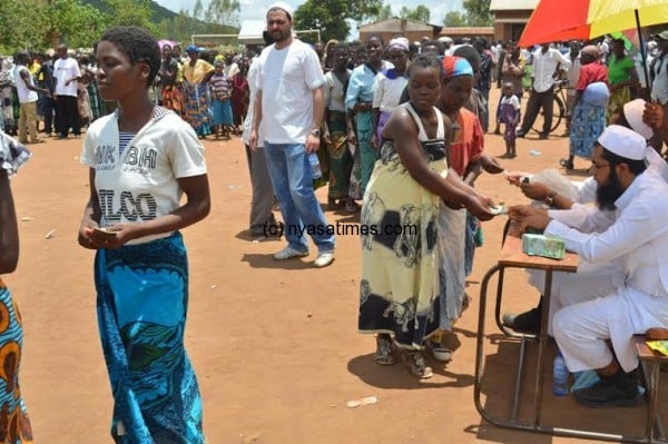 Migowi flood victims recieving cash before they receve a pack of asorted items