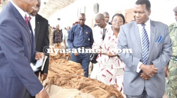 Minister of Agriculture George Chaponda (R) inspecting the leaf at Limbe Auction Floors