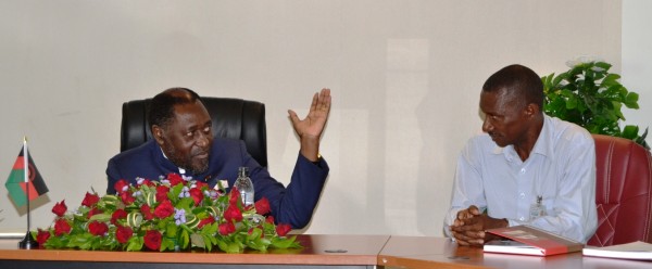 Minister of Labour and Man Power Development, Hon. Henry Mussa, asures Malawi Ex-TEBA Mine Workers President, John Dick to be assisted at the press briefing at Capital Hil in LL-(c) Abel Ikiloni, Mana