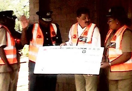 Mirza handing a cheque to Commissioner of Police George Kainja