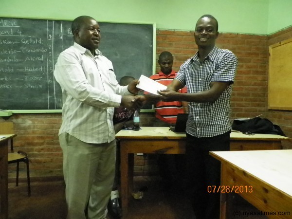 Mphungu receives his K50,000 cheque from Chessam president, Pic Leonard Sharra, Nyasa Times