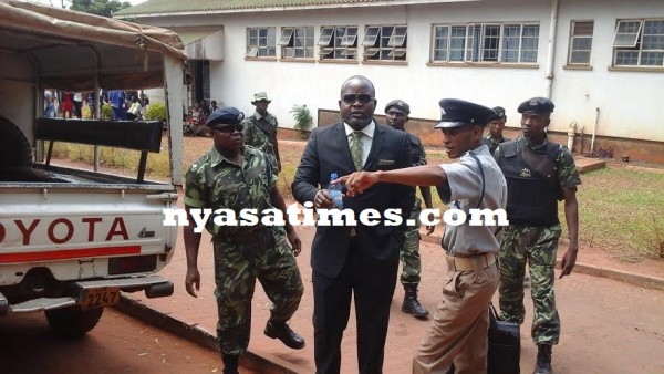 Mphwiyo surrounded by police officers at the court