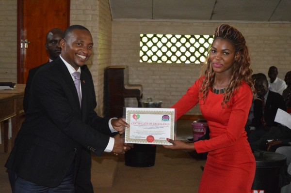 Mr.Mayamiko Mwinjiro,chairperson of BEAM Trust (L) presents Award Certificate to the Director of Atsikana Pa Ulendo Private Secondary School of Nsaru,Lilongwe West Division (C) Stanley Makuti