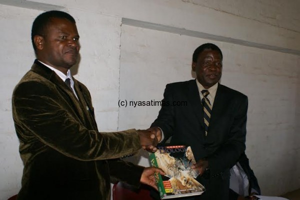 Msiska (left) receiving a symbolic book from Nyali.