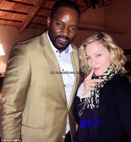 Musicians Madonna (right) posed for a photograph with Malawian hip hop star Tay Grin (left) at a party yesterday to celebrate the singer's first visit to the African country for 18 months