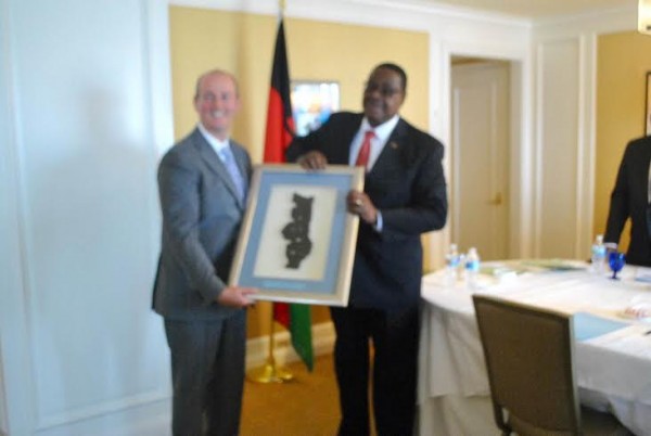 Mutharika receiving a gift from Universal Leaf boss