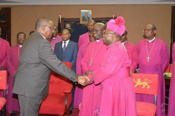 Mutharika shaking hands with one of the bishops