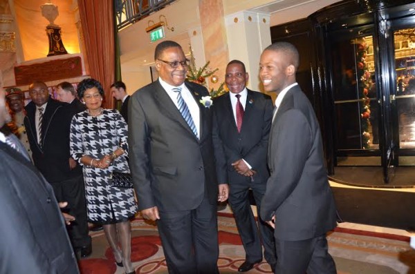 Mutharika smiling with a boy on arrival at his hotel in London