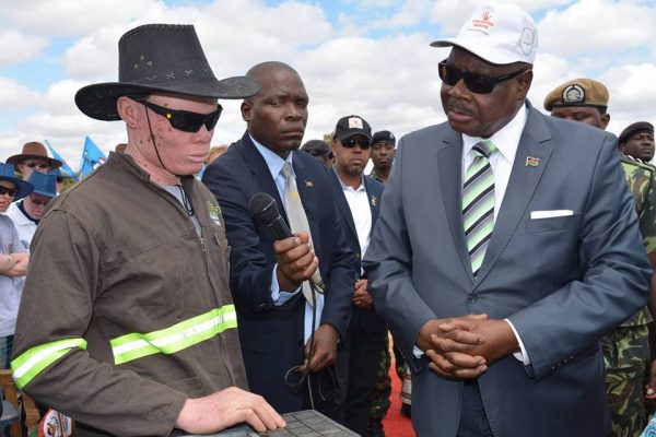 Mutharika speaking to  a person with albinism