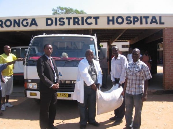 Mwambande presenting bag of maize to hospital officials