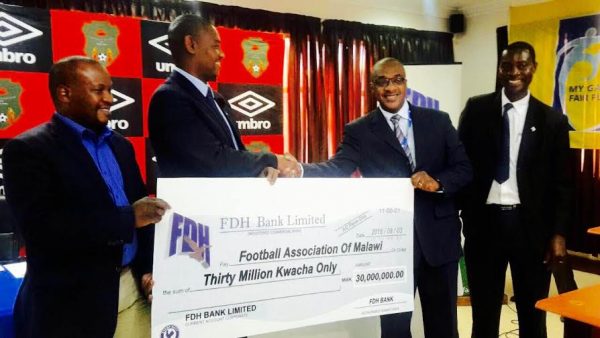Nyamilandu receives the cheque from Outtara of FDH bank