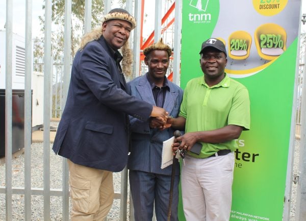 Nyirenda (R) shaking hands with Group Village headman Kunenekude (M) and Katsonga (L) officailly handing over the tower.
