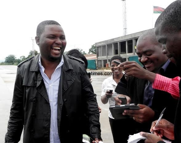 One of the first passengers cracks a joke with journalists as he is about to board the plane to Lilongwe- Pic Lucky Mkandawire
