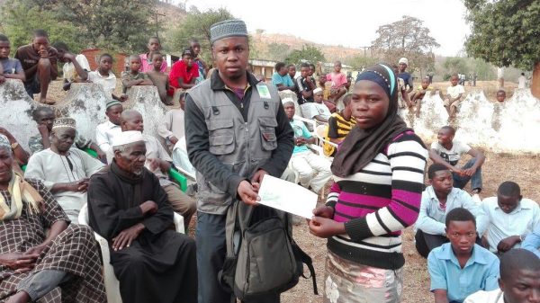 Oscar Mudzumwe, an official giving the money to needy students