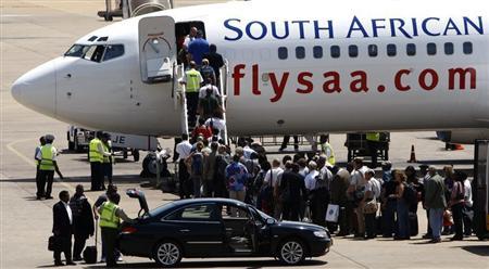 Passengers board a South African Airways Boeing 737 aircraft at the Kamuzu International Airport in Lilongwe October 25, 2009. REUTERS/Siphiwe Sibeko