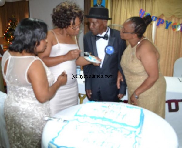 Pastor Ziba (Retired) is fed a cake by  daughters . Pix by Gospel Mwalwanda